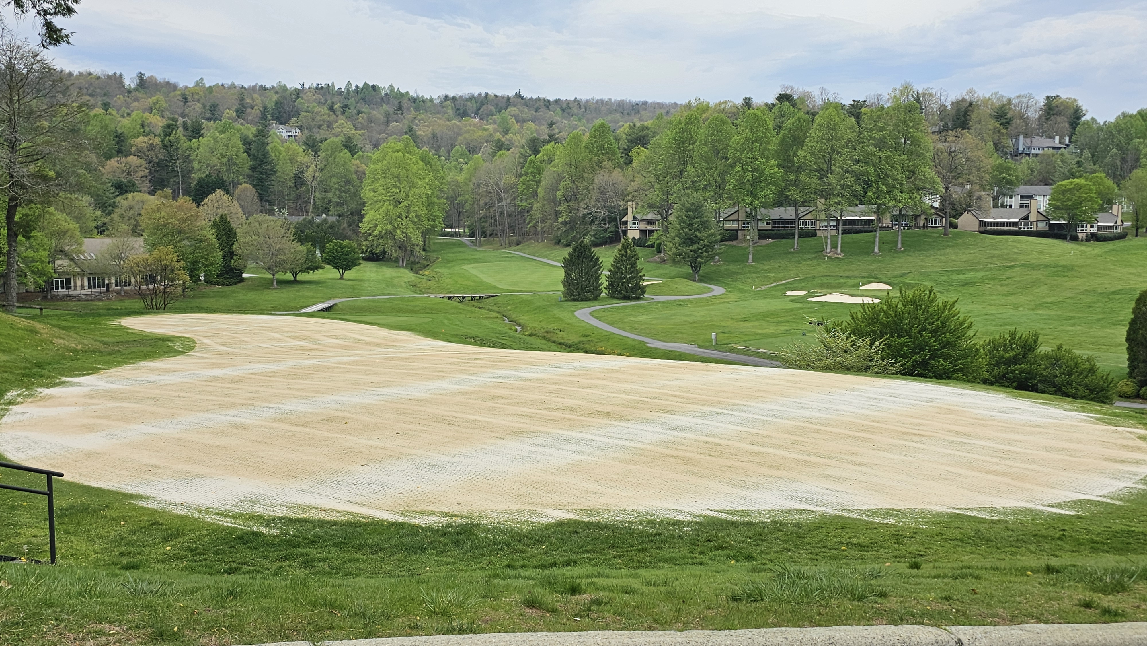 Wide view of a topdressed fairway covered in an even layer of sand with mountain backdrop.